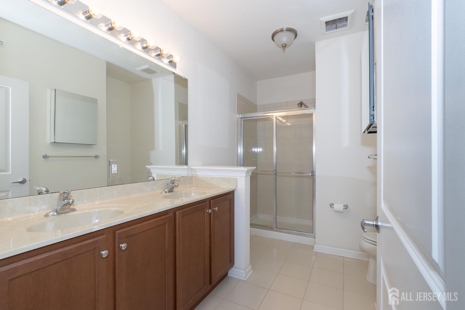 541 East Celebration Way South Plainfield, NJ 07080 - Photo 19 of 35 a bathroom with a granite countertop sink shower and a mirror