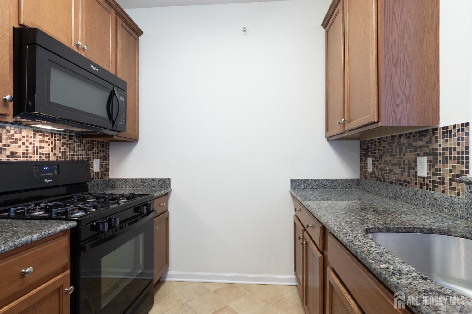 541 East Celebration Way South Plainfield, NJ 07080 - Photo 10 of 35 a kitchen with stainless steel appliances granite countertop a sink stove and microwave