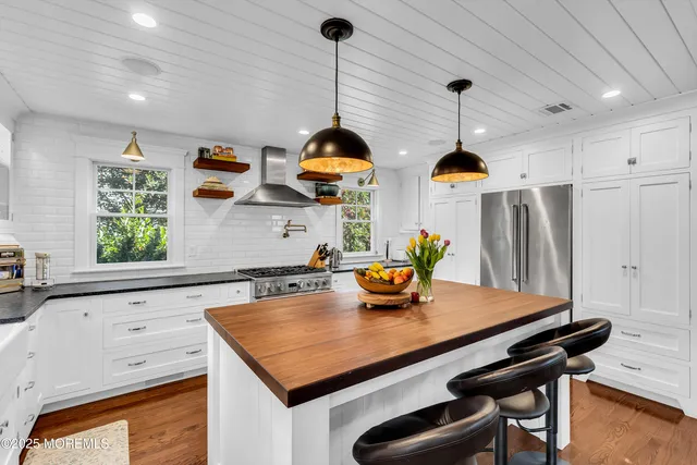 a kitchen with stainless steel appliances a sink a window and wooden floor