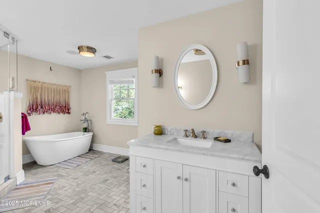 a bathroom with a granite countertop sink a mirror and shower