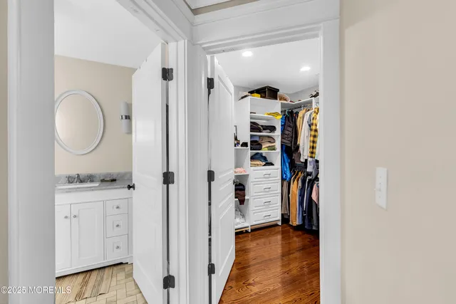 a bathroom with a sink a mirror a toilet and a window