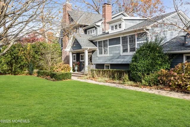 a front view of a house with a yard and trees
