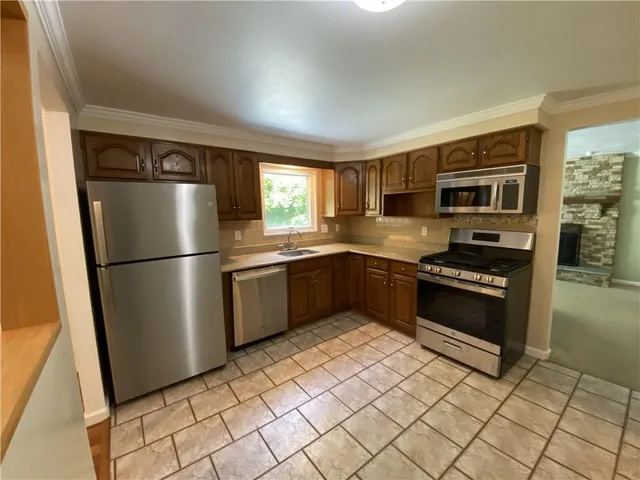 a kitchen with granite countertop a refrigerator and a stove top oven