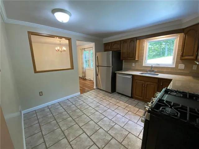 a kitchen with stainless steel appliances granite countertop a refrigerator and a sink