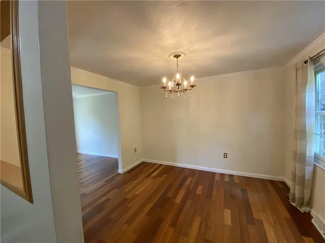 a view of a room with wooden floor and chandelier