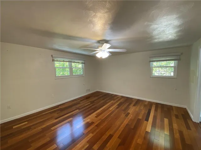 a view of wooden floor and chandelier fan in a room