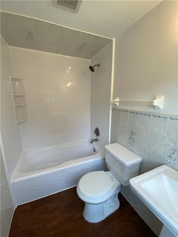 a bathroom with a toilet and a bath tub
