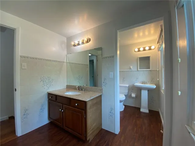 a bathroom with a granite countertop sink toilet a mirror and vanity