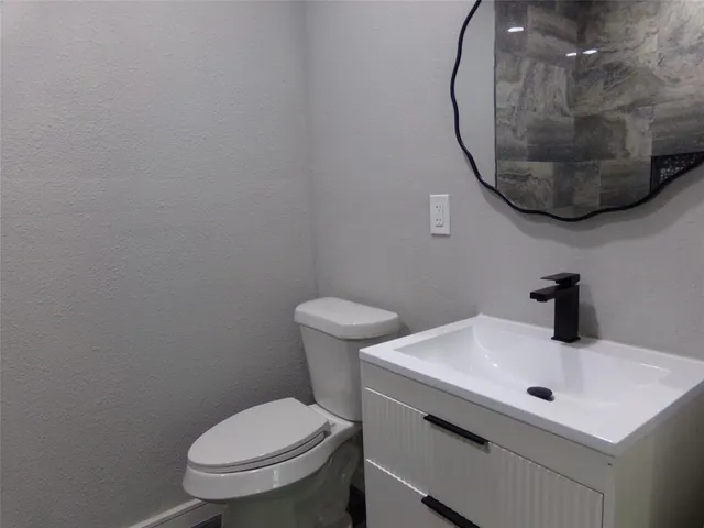 a bathroom with a sink a toilet and a mirror