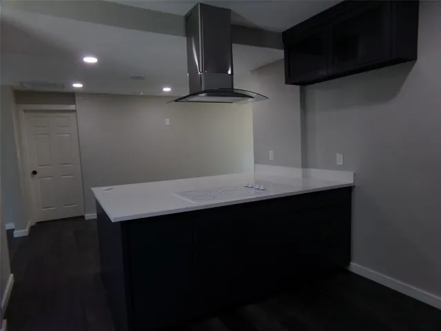 a kitchen with a sink cabinetry and wooden floor