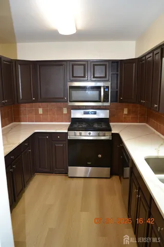 a kitchen with stainless steel appliances a stove a sink and a microwave