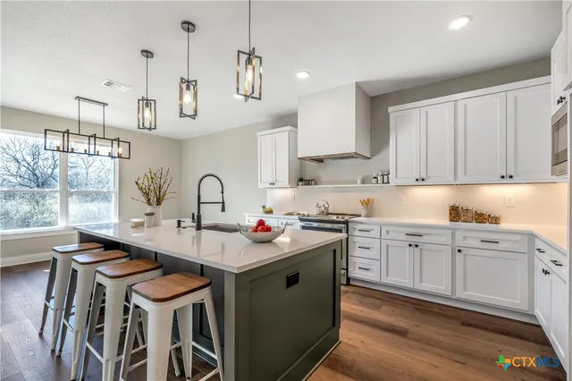a kitchen with stainless steel appliances granite countertop a sink and cabinets