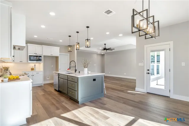 a kitchen with kitchen island a sink stainless steel appliances and cabinets