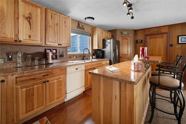 a kitchen with stainless steel appliances kitchen island granite countertop a sink and cabinets
