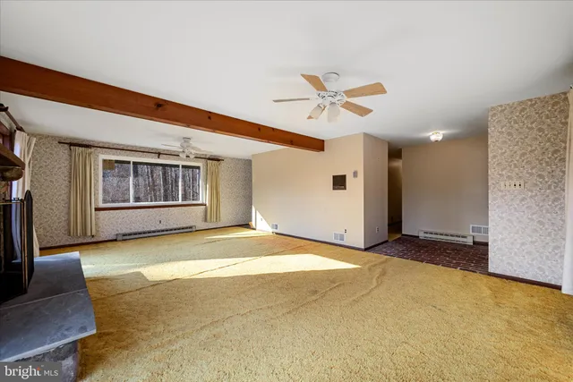a view of an empty room with a fireplace and a window