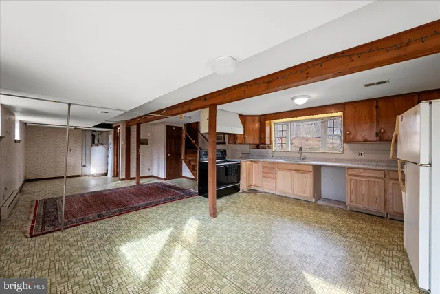 a kitchen with a sink cabinets and wooden floor