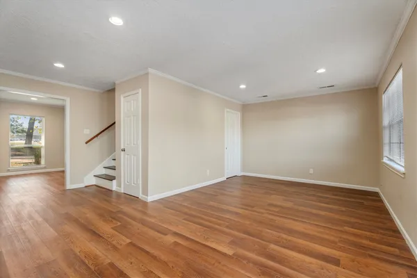 a view of empty room with wooden floor and window