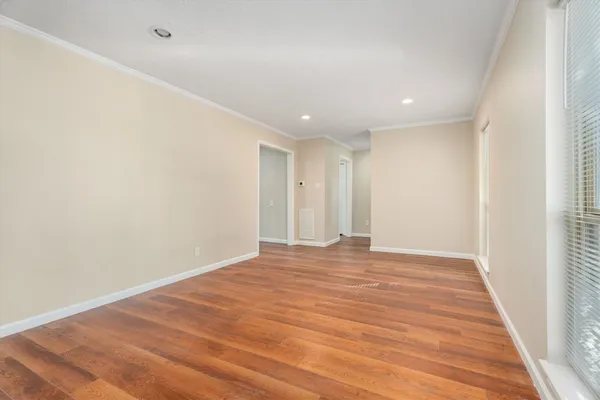 a view of an empty room with wooden floor