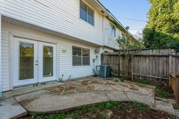 a view of a backyard with plants and wooden fence