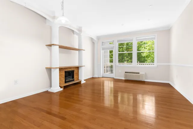 a view of empty room with wooden floor and fireplace