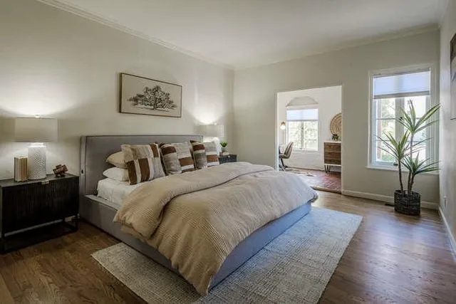 a bedroom with bed and wooden floor