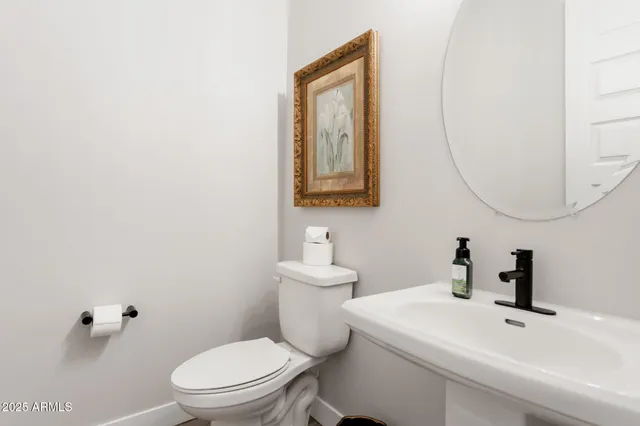 a bathroom with a sink a toilet a mirror and shower