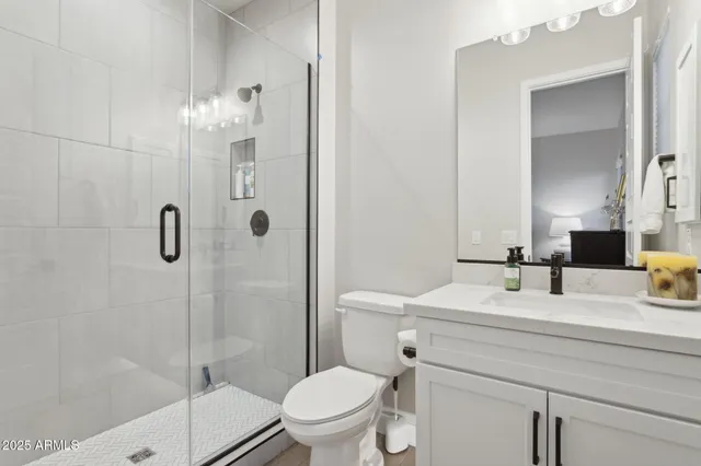 a bathroom with a double vanity sink and mirror with shower