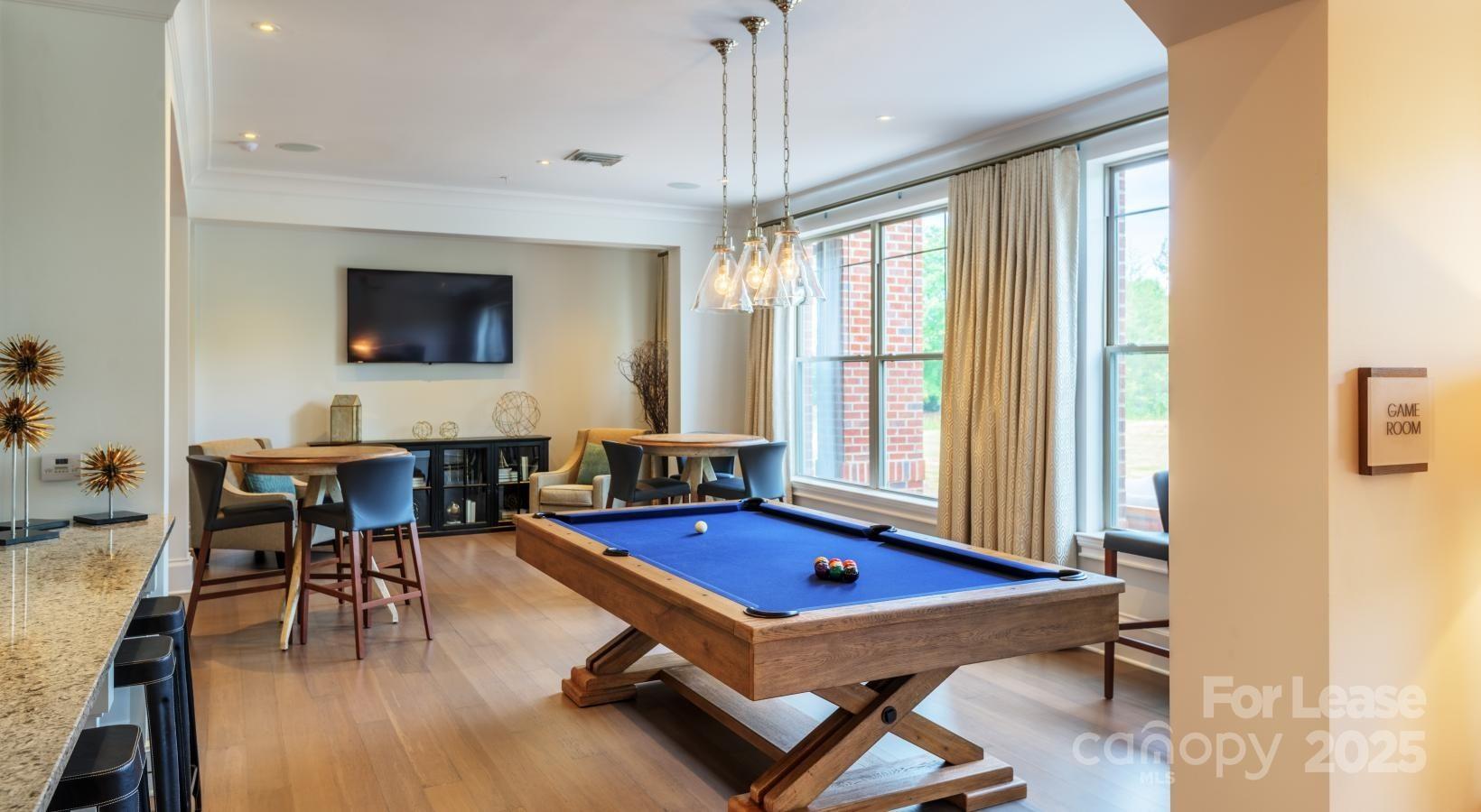 10624 Parrish Street, Unit A1 Matthews, NC 28105 - Photo 28 of 42 a living room with furniture pool table and a flat screen tv