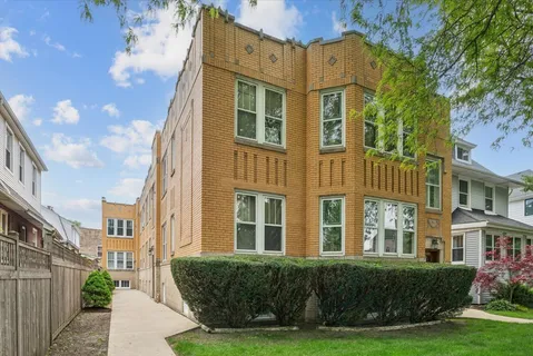 a front view of a residential apartment building with a yard