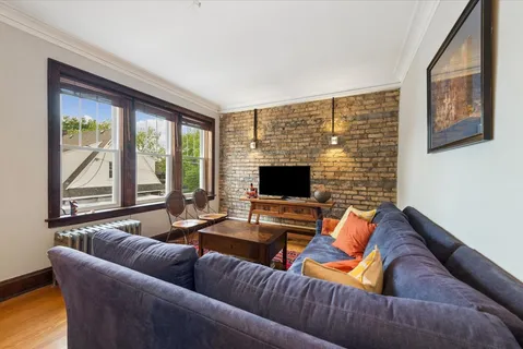 a living room with furniture flat screen tv and a large window