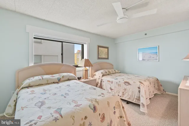 a bedroom with two beds and a chandelier
