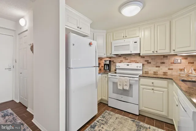a kitchen with a refrigerator sink stove and cabinets