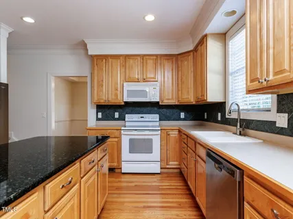 a kitchen with granite countertop a sink stove and cabinets
