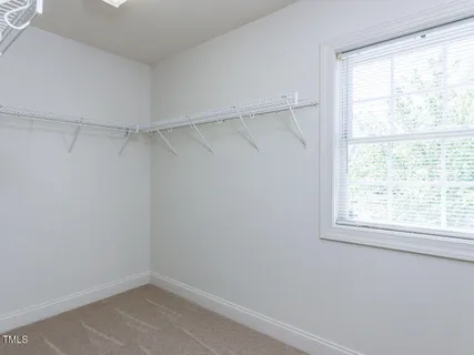 an empty room with windows and ceiling fan