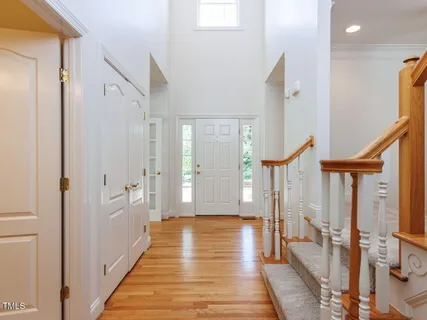 a view of a hallway with wooden floor and staircase
