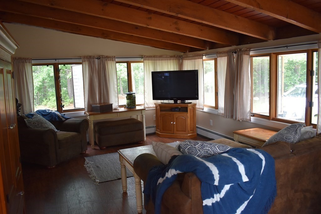 371 Worcester Road Charlton, MA 01507 - Photo 13 of 35 a living room with furniture a flat screen tv and a floor to ceiling window