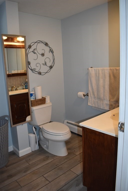371 Worcester Road Charlton, MA 01507 - Photo 26 of 35 a white toilet sitting next to a bathroom sink and a mirror