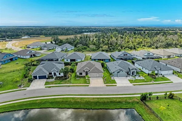 an aerial view of residential houses with outdoor space and ocean view