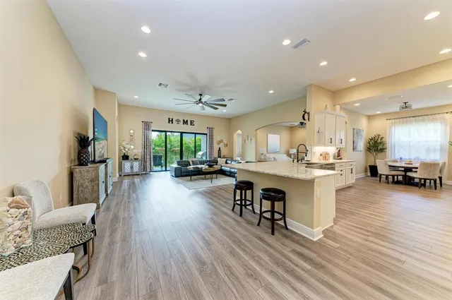 a large kitchen with granite countertop lots of counter space and view of living room