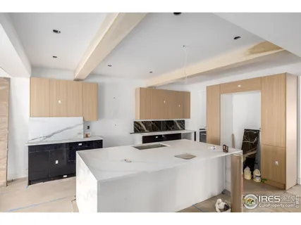 a kitchen with stainless steel appliances a sink a stove a refrigerator a center island and cabinets