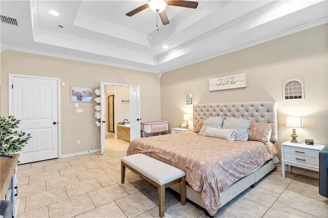 a bedroom with a large bed a rug and chandelier
