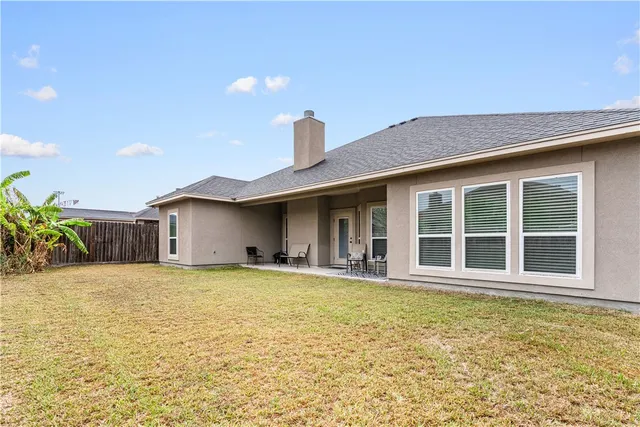 a view of a house with a yard and potted plants