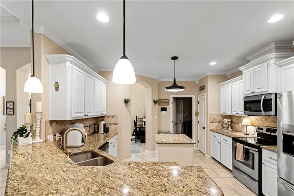a kitchen with stainless steel appliances granite countertop a stove a sink and a microwave