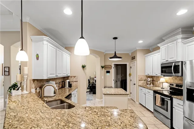 a kitchen with stainless steel appliances granite countertop a stove a sink and a microwave