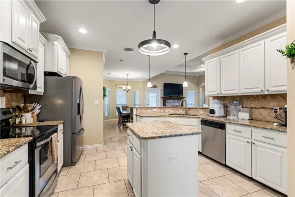 a kitchen with stainless steel appliances granite countertop a sink stove and refrigerator