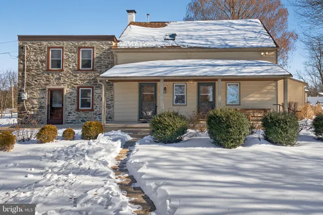 a view of a house with snow on the side of the road