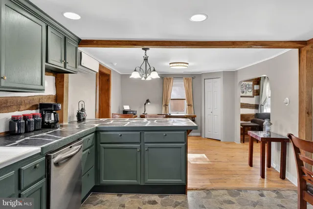 a kitchen with stainless steel appliances granite countertop a table chairs sink and stove top oven