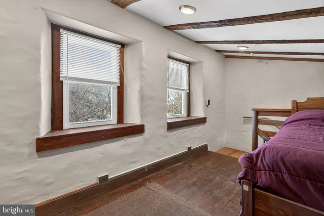 a bed sitting in a bedroom next to a larger window