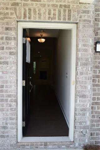 a view of a hallway with wooden floor and a kitchen