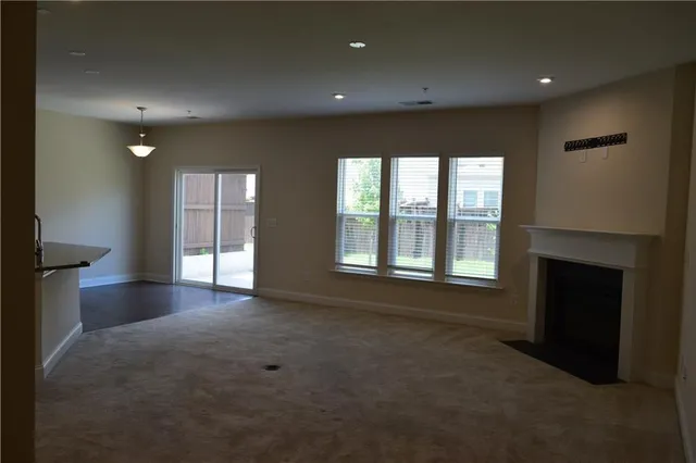 a view of kitchen with kitchen island stainless steel appliances a sink cabinets and a window